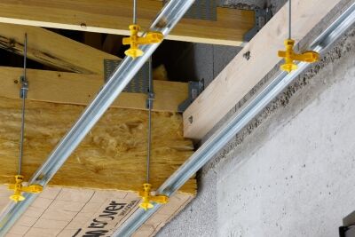 Plusieurs clips plenum Intégra 2 Isover installés pour maintenir la laine isolante au plafond
